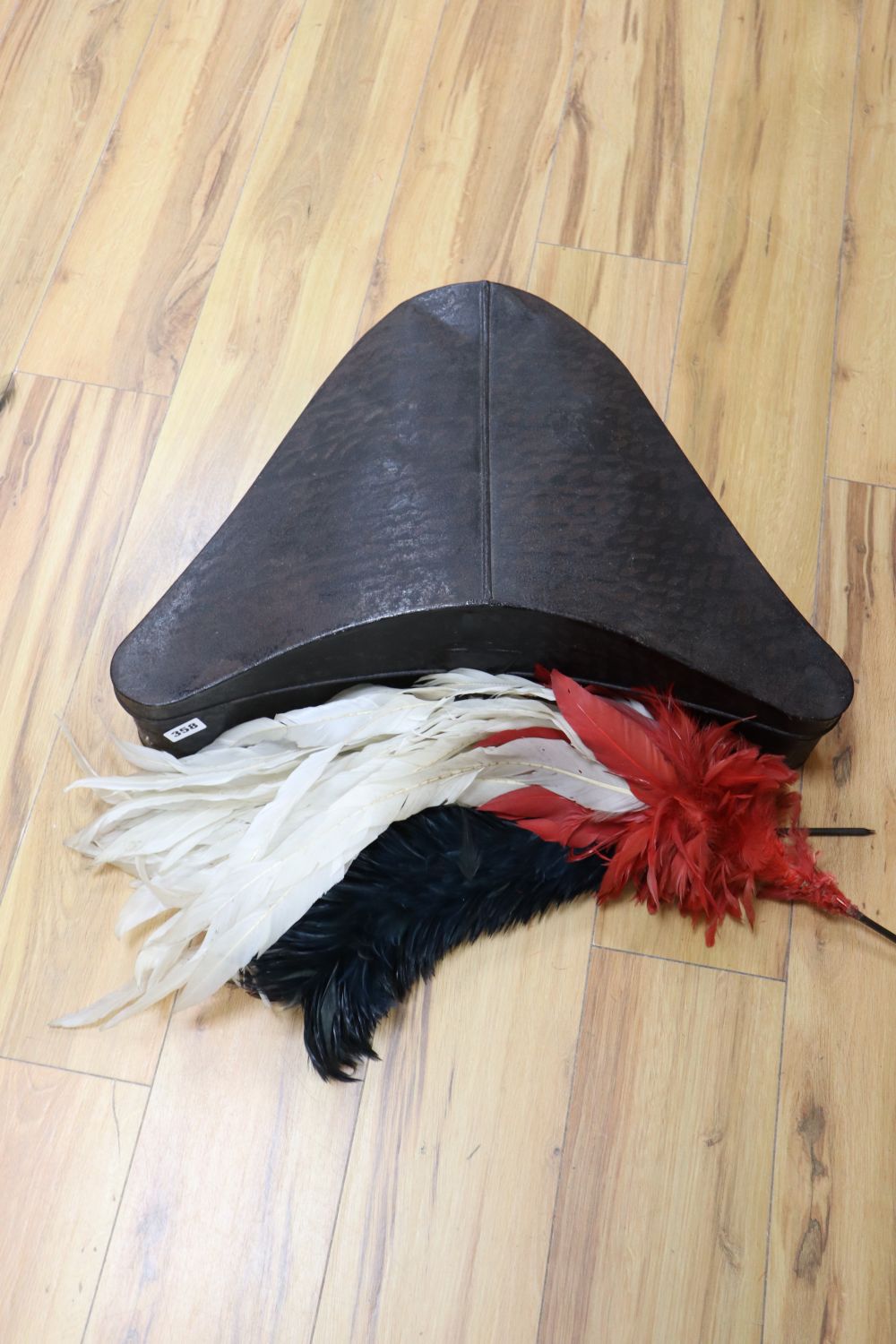 A tri-corn hat tin with plumes